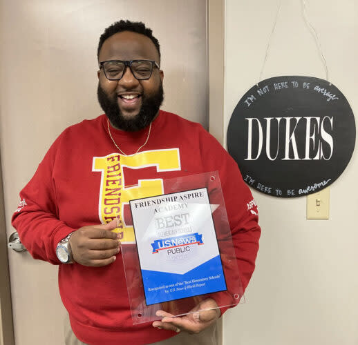 Friendship Aspire Principal Jherrithan Dukes celebrates as he receives a plaque honoring the school as one of the best in Arkansas. (Greg Toppo/The 74)