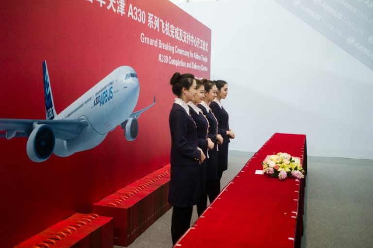 Hostesses wait for guests during a ceremony to mark the beginning of construction on a new Airbus facility in Tianjin, on March 2, 2016