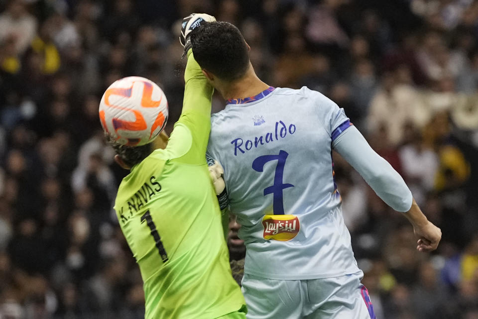 Cristiano Ronaldo goes for the header playing for a combined XI of Saudi Arabian teams Al Nassr and Al Hilal is challenged by PSG's goalkeeper Keylor Navas during a friendly soccer match, at the King Saud University Stadium, in Riyadh, Saudi Arabia, Thursday, Jan. 19, 2023. (AP Photo/Hussein Malla)