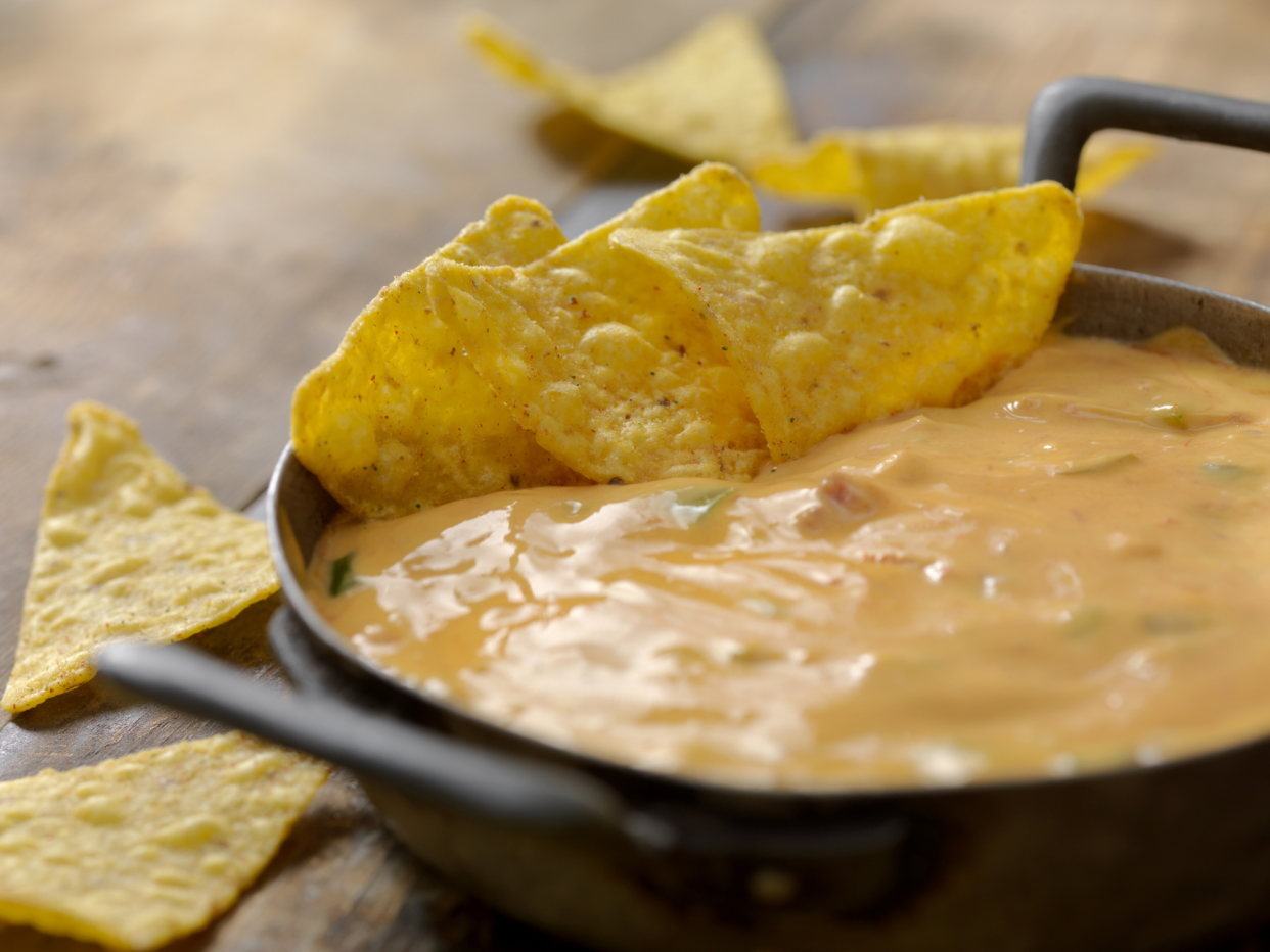 Tortilla Chips in Yellow Tex-Mex Cheese Dip in a Cast Iron Skillet, Selective Focus