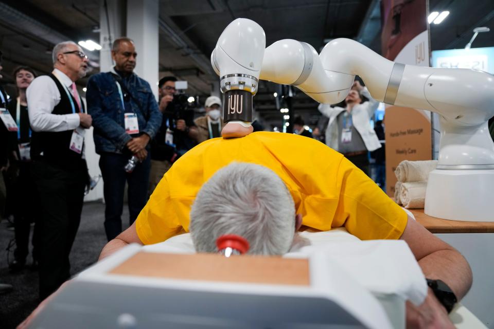 An attendee receives a massage from the iYU AI-assisted massage robot, by Capsix Robotics during the CES tech show Wednesday, Jan. 10, 2024, in Las Vegas.