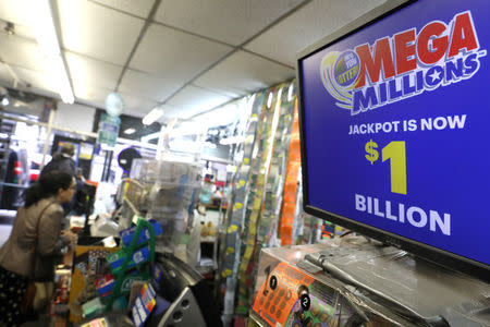 A sign displays the jackpot for Mega Millions as customers buy lottery tickets in midtown Manhattan in New York, U.S., October 19, 2018. REUTERS/Mike Sugar