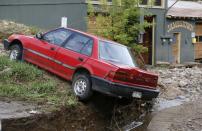 A car is perched on a dirt bank in Jamestown, Colorado, after a flash flood destroyed much of the town, September 14, 2013. Relentless rains pounded flood-ravaged eastern Colorado for a fifth day on Saturday, triggering more evacuations and warnings as rescuers tried to reach thousands of people displaced or stranded by the deluge that has been blamed for at least four deaths. REUTERS/Rick Wilking