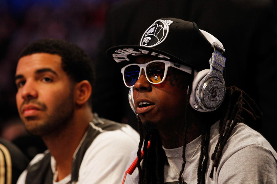 Lil Wayne and Drake wearing black and white at a basketball game