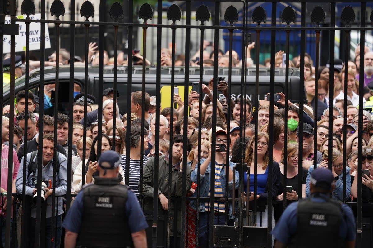 Members of the public stand outside the gates of Downing Street (PA Wire)