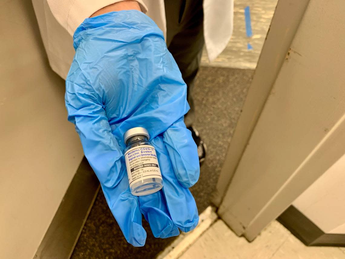 A nurse at a Walgreens pharmacy near Florida International University’s Tamiami campus on 107th Avenue in Miami-Dade shows a patient the newly-formulated Moderna bivalent vaccine on Sept. 7, 2022. The vaccine is an ‘updated booster’ designed to target not only the original COVID strain, but also omicron strains.