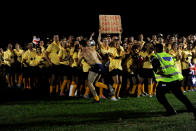 A man is chased by security as he runs in his underwear past over 1000 Australian fans spelling out the word G'Day on Clapham Common in London, Wednesday, July 25, 2012. The fans attempted to break the Guinness World record for The Most People Wearing The Same Full Team Kit.