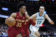 Cleveland Cavaliers forward Isaac Okoro (35) drives against Charlotte Hornets forward Aleksej Pokusevski (17) during the first half of an NBA basketball game, Monday, March 25, 2024, in Cleveland. (AP Photo/Ron Schwane)
