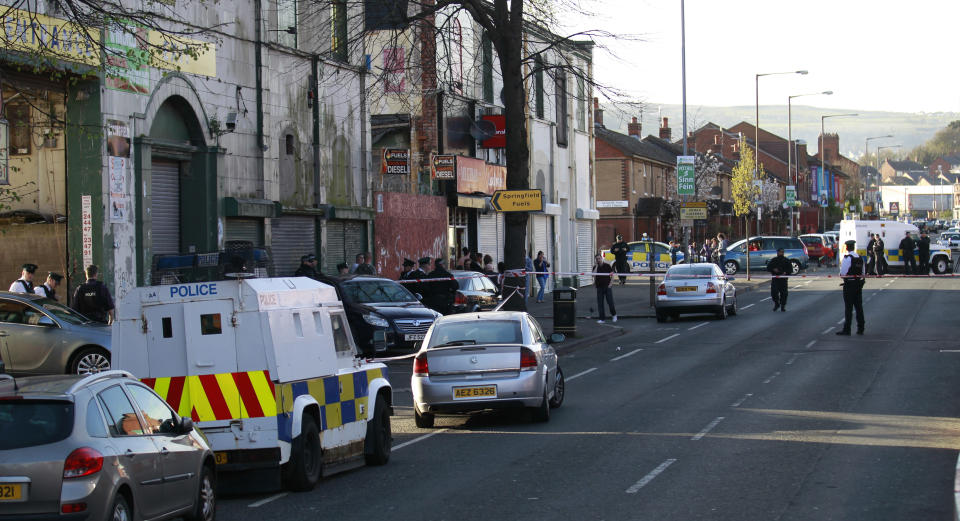 Police officers secure the area close to where a prominent dissident republican was shot dead in west Belfast, Northern Ireland, Friday, April, 18, 2014. A senior Irish Republican Army hard-liner has been shot to death in Belfast three years after former comrades in his splinter group threatened to kill him. Nearby residents say gunmen escorted the victim, 43-year-old Tommy Crossan, to a fuel depot overlooked by houses and shot him in the head and body at close range. No group claimed responsibility. Police and politicians blamed Crossan’s former group, the Continuity IRA, for following through on 2011 death threats against him. The Continuity IRA accused him of keeping money from robberies and providing information on colleagues to British intelligence agents. Crossan denied this and refused to flee his native Catholic west Belfast. The major IRA faction, the Provisionals, renounced violence in 2005 but other militant groups remain active. Their last killing was in October. (AP Photo/Peter Morrison)