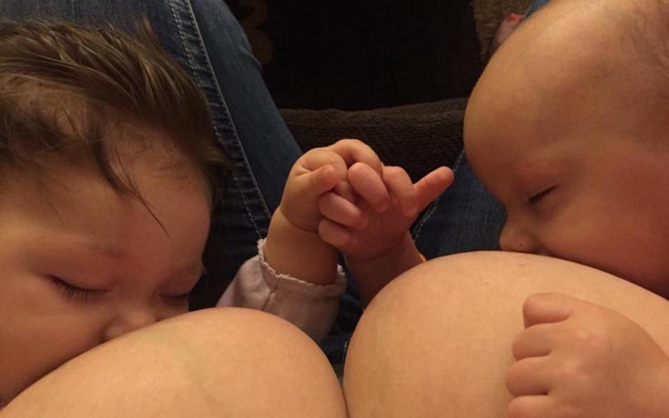 Rebecca Wanosik breastfeeding two babies while they hold hands - Credit: Rebecca Wanosik/Facebook