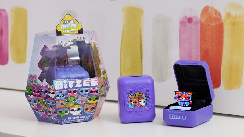 A photo of the Bitzee digital pet in its retail packaging, with the lid closed, and with the lid open.