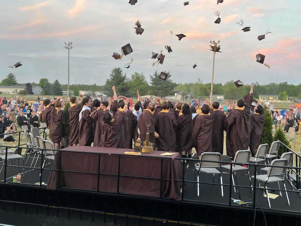 The Pellston Class of 2023 throw their graduation caps in the air.