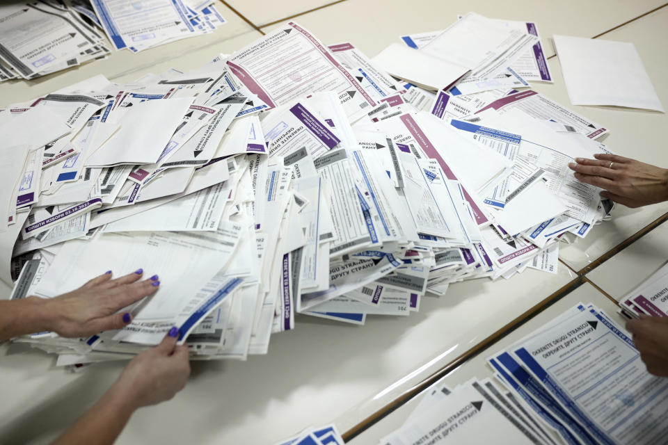 Election Commission officials count votes after general election in Sarajevo, Bosnia, Sunday, Oct. 2, 2022. Polls opened Sunday in Bosnia for a general election that is unlikely to bring any structural change despite palpable disappointment in the small, ethnically divided Balkan country with the long-established cast of sectarian political leaders. (AP Photo/Armin Durgut)