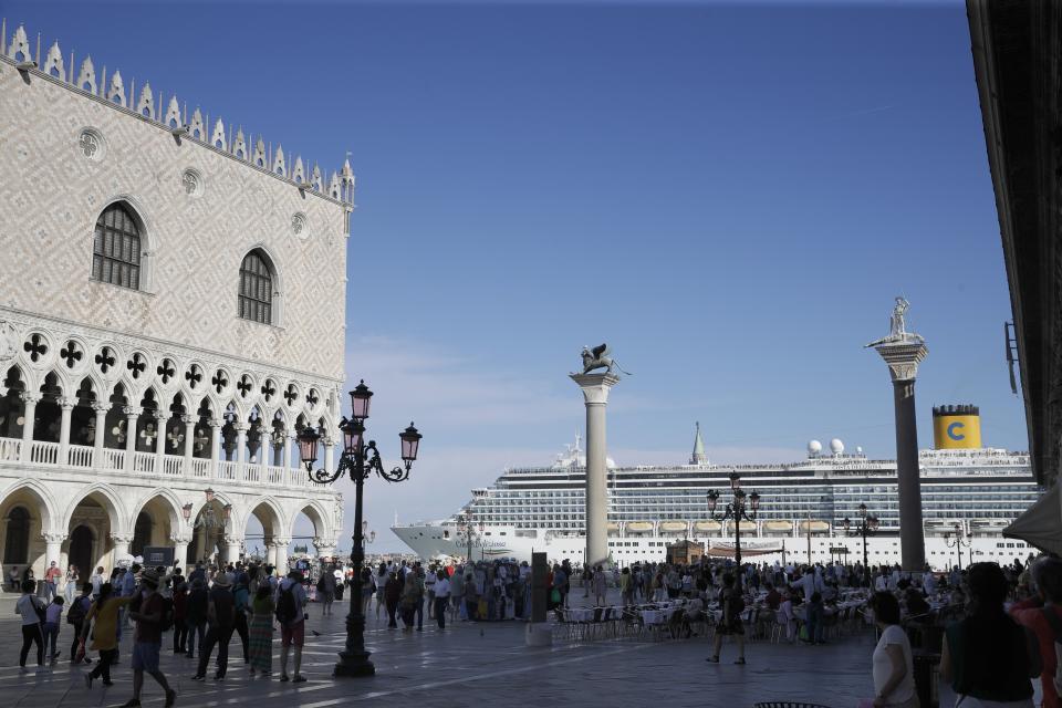 FILE-- A cruise ship passes by St. Mark's Square in Venice, Italy, Sunday, June 2, 2019. Declaring Venice's waterways a “national monument,” Italy is banning mammoth cruise liners from sailing into the lagoon city, which risked within days being declared an imperiled world heritage site by the United Nations. Culture Minister Dario Franceschini said the ban will take effect on Aug. 1 and was urgently adopted at a Cabinet meeting on Tuesday. (AP Photo/Luca Bruno)