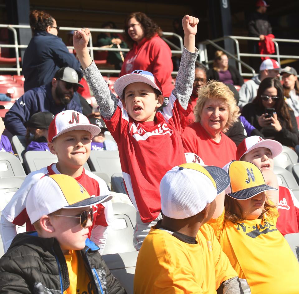 Sebastian Briggs of the Minor League Wildcats is excited on the opening day of the Norwich Little League at Dodd Stadium in Norwich Saturday. At left is teammate Sam Piacenza and at right is coach Kelley LaCombe. According to League President Darek Pietruczuk, there are 261 boys and girls on 24 teams.