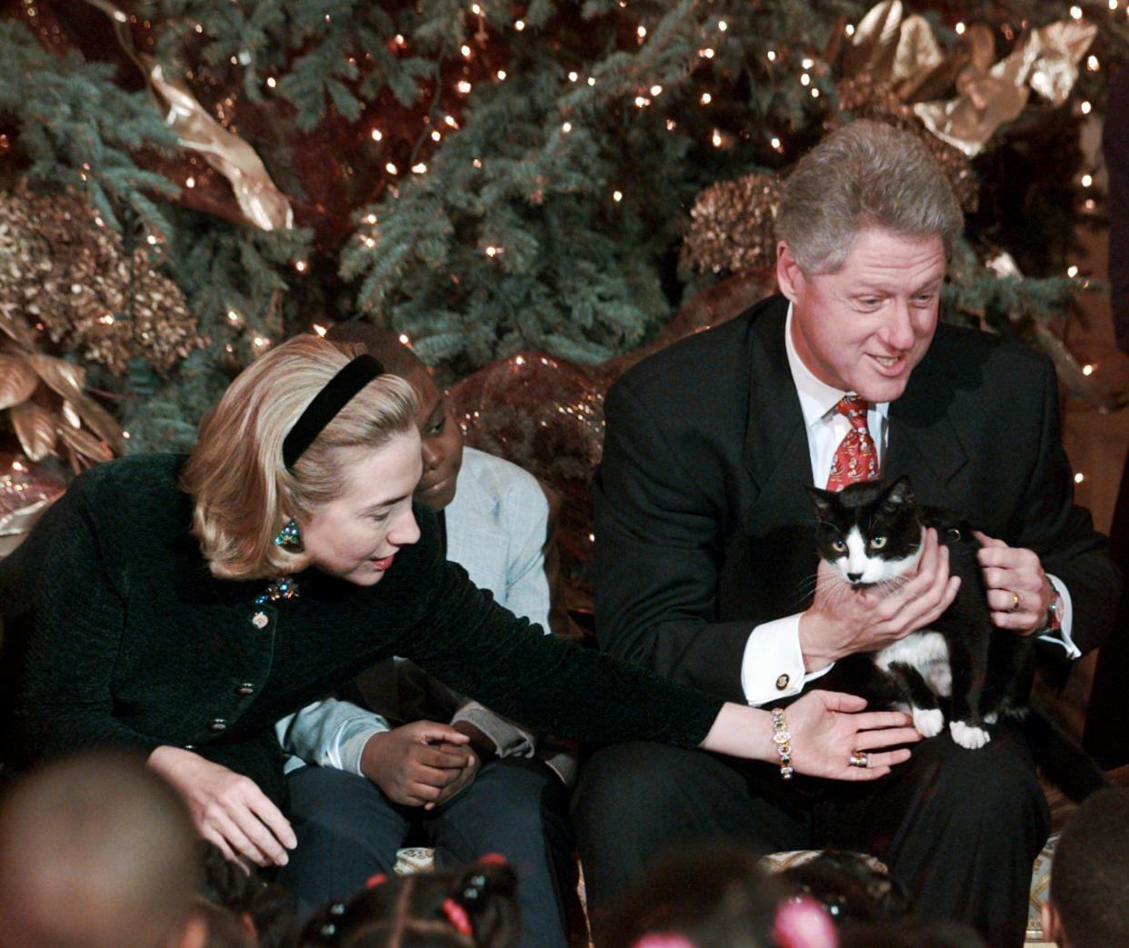 In this Dec. 20, 1996, file photo President Clinton holds Socks the cat as he and first lady Hillary Clinton host Washington area elementary school children at the White House where the president read "Twas the Night Before Christmas." The arrival of the Biden pets will also mark the next chapter in a long history of pets residing at the White House after a four-year hiatus during the Trump administration. “Pets have always played an important role in the White House throughout the decades,” said Jennifer Pickens, an author who studies White House traditions.  (AP Photo/Ruth Fremson, File)