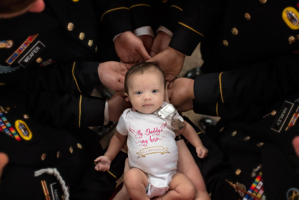 Baby Christian Harris in the arms of the soldiers that served along with her father before he died in action. Source: Pinehurst Photography