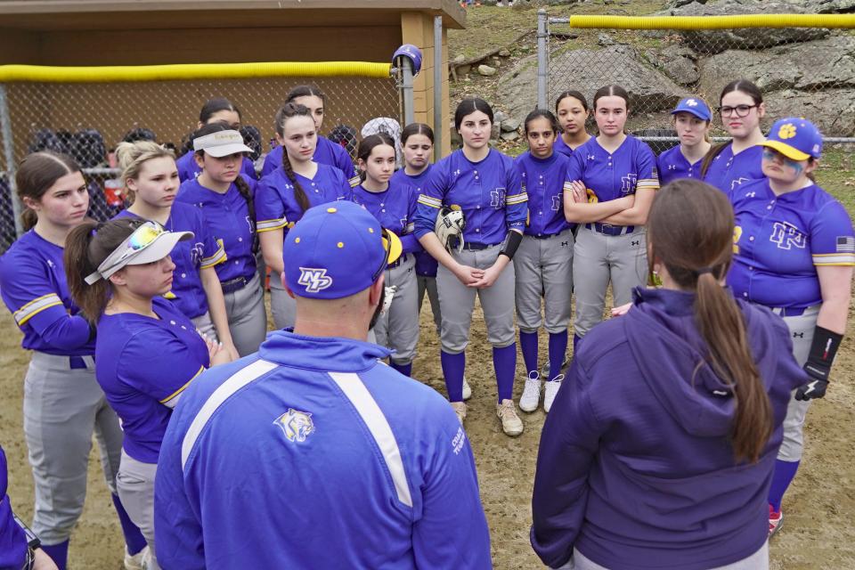 Members of the LNP softball team listen intently as coaches Michael Tuorto and Alyssa McCoart give their pregame speech prior to the co-op team's game against West Warwick at Notte Park on Wednesday.