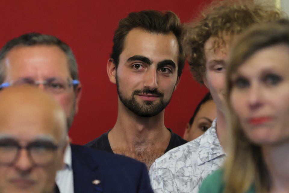 Henri, right, the 'backpack hero' , listens to French President Emmanuel Macron delivering a speech as he meets rescue forces in Annecy, French Alps, Friday, June 9, 2023. A man with a knife stabbed four young children at a lakeside park in the French Alps on Thursday June 8, 2023, assaulting at least one in a stroller repeatedly. The 24-year-old man in France is being hailed as a hero after he intervened in a savage knife attack on very young children. (Denis Balibouse/Pool via AP)