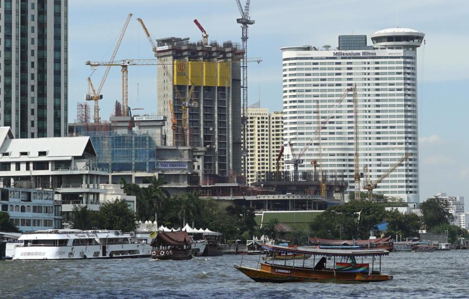 A riverboat taxi crosses the Chao Phraya river in front of massive construction projects Wednesday, Jan. 18, 2017, in Bangkok, Thailand. A United Nations report says Asia's economic outlook for 2017 is strong despite slowing global growth due to sluggish international trade and investment. (AP Photo/Dake Kang)