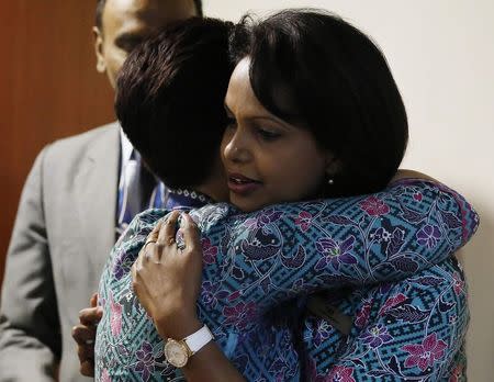 Malaysia Airlines air stewardesses hug before a memorial for victims of MH370 and MH17 at Malaysia Airlines headquarters in Kuala Lumpur July 25, 2014. REUTERS/Olivia Harris