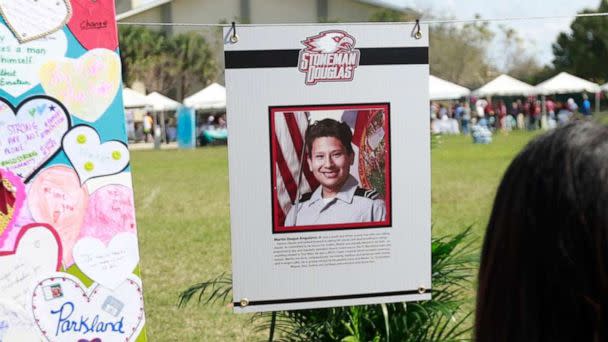 PHOTO: Attendees at Trails End Park look at  memorial for Martin Duque Anguiano, one of the 17 that was killed during the Marjory Stoneman Douglas High School shooting in Parkland, Fla., Feb. 14, 2019.  (Wilfredo Lee/AP, FILE)