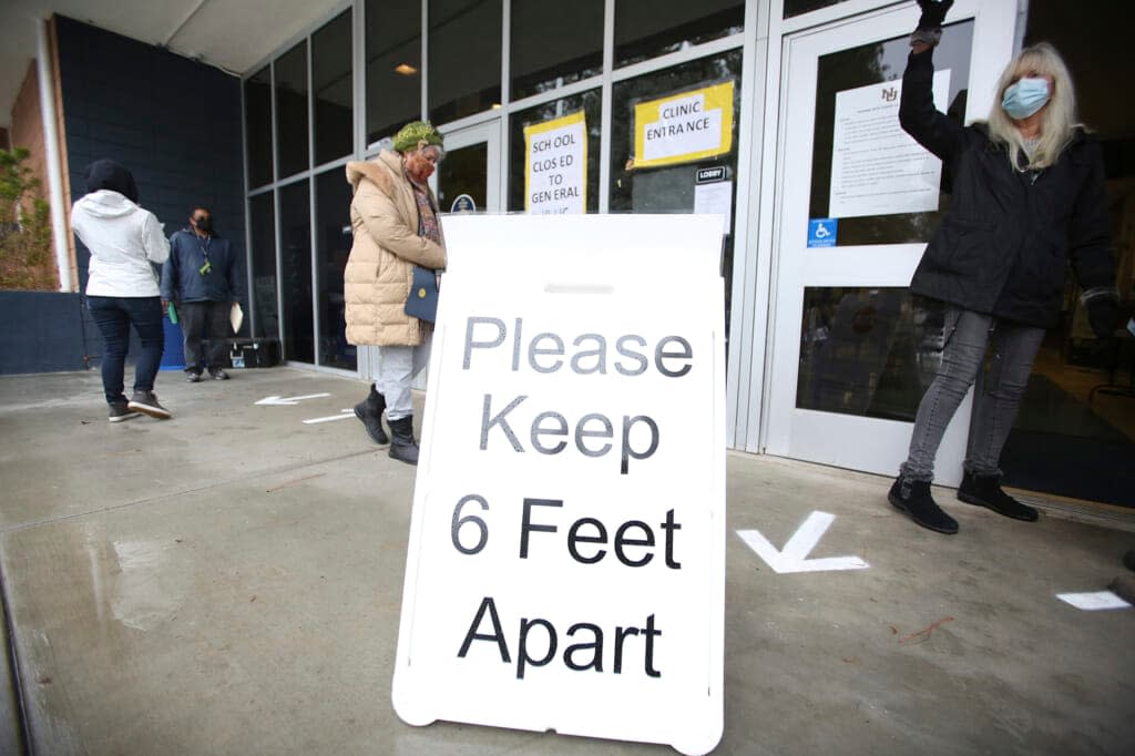 A sign asks those getting vaccinated to keep 6 feet apart during the vaccination event, Wednesday, Jan. 27, 2021, at Nevada Union High School in Grass Valley, Calif. (Elias Funez/The Union via AP, File)