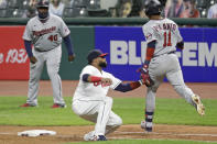 Cleveland Indians' Carlos Santana, center, tags out Minnesota Twins' Jorge Polanco, right, at first base in the seventh inning in a baseball game, Tuesday, Aug. 25, 2020, in Cleveland. (AP Photo/Tony Dejak)