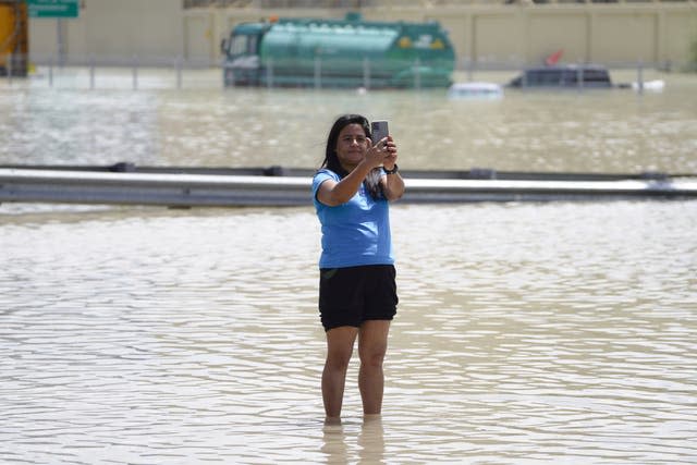 A woman takes a selfie in floodwater in Dubai