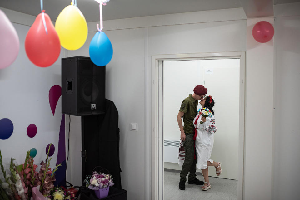 Vladyslav, 27, kisses his wife, Anastasiia, 18, as they arrive in a modular town for their wedding celebration in Bucha, Ukraine, on Aug. 25, 2022. Vladyslav and Anastasiia met in Sloviansk days before the full-scale Russian invasion on Feb. 24, 2022.