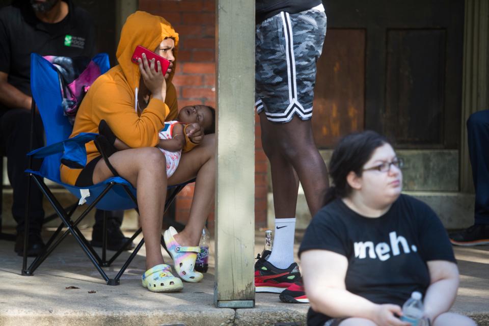 Residents wait outside of 808 to 820 N. Adams St. in Wilmington after being displaced when their homes were suddenly condemned Monday, May 16, 2022.