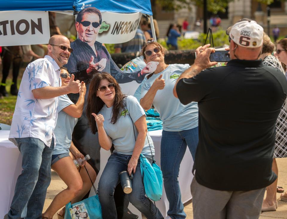 Martin Levin and family members pose for a photo with a cutout of Fred Levin during Fred Levin Way Fest in downtown Pensacola on April 24.