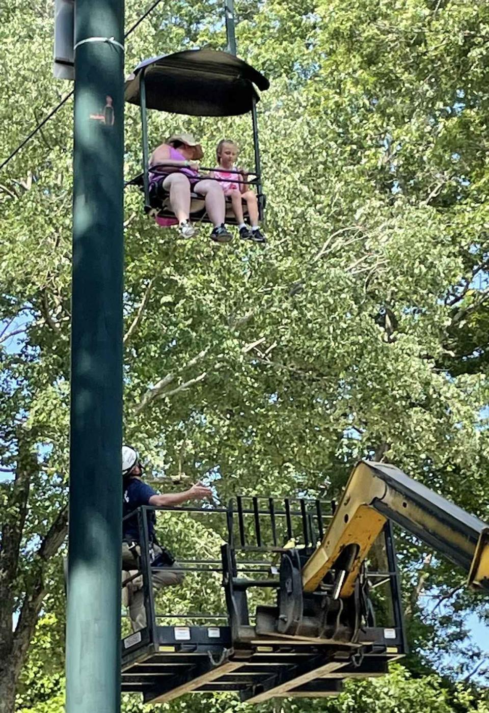 A crewmember works to rescue a woman and a child from a sky ride that broke down Friday at Southwick's Zoo in Mendon.