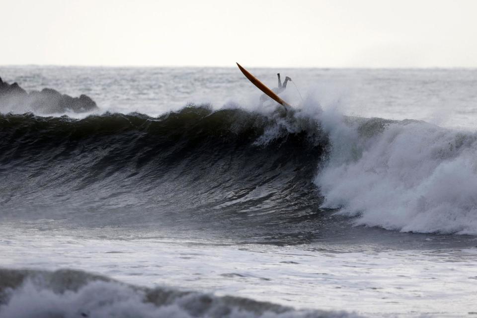PHOTO: A surfer falls off a surfboard while going over a wave in Ventura, California, December 31, 2023. (Caroline Brehman/EPA via Shutterstock)