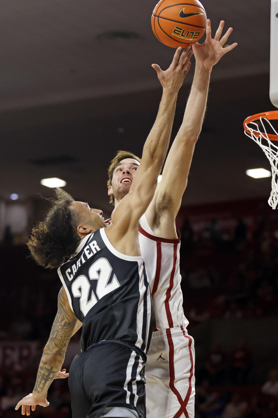 Providence guard Devin Carter (22) shoots against Oklahoma forward Sam Godwin, right, during the first half of an NCAA college basketball game, Tuesday, Dec. 5, 2023, in Norman, Okla. (AP Photo/Nate Billings)