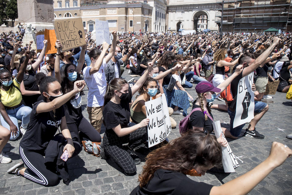 People kneel as they gather calling for justice for George Floyd, who died May 25 after being restrained by police in Minneapolis, USA, in Rome's Piazza del Popolo square, Sunday, June 7, 2020. People have been protesting throughout Italy to denounce the police killing of George Floyd and show solidarity with anti-racism protests in the U.S. and elsewhere. (Roberto Monaldo/LaPresse via AP)