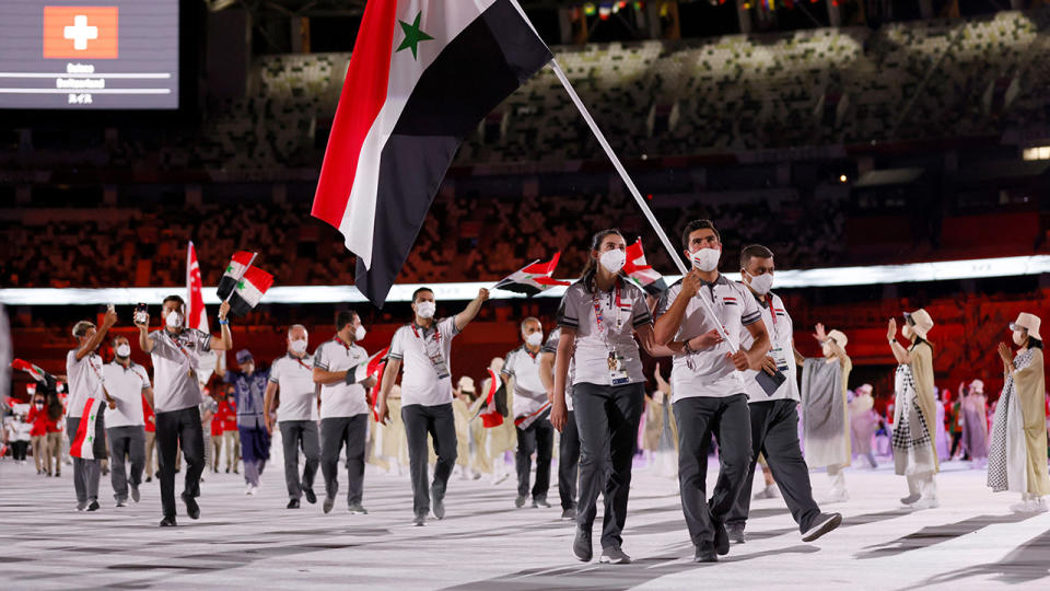 Syria's flag bearers Hend Zaza and Ahmad Saber Hamcho  lead their delegation as they parade during the opening ceremony of the Tokyo 2020 Olympic Games. (Photo by ODD ANDERSEN/AFP via Getty Images)