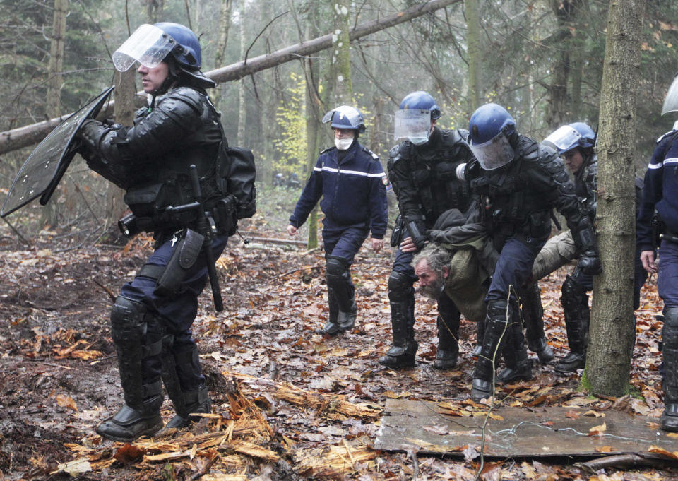 FILE - This Nov. 24, 2012 file photo shows French gendarmes detaining a protester during an evacuation operation on land that will become the new airport in Notre-Dame-des-Landes, western France. An unlikely alliance of anarchists and beret-wearing farmers is creating a headache for President Francois Hollande’s beleaguered government by mounting an escalating Occupy Wall Street-style battle that has delayed construction on the ambitious airport near the city of Nantes for months. (AP Photo/Laetitia Notarianni, File)