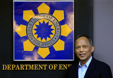 Philippine Department of Energy (DOE) Secretary Alfonso Cusi poses for a picture beside the DOE logo after a Reuters interview at the DOE headquarters in Taguig city, Metro Manila, Philippines February 27, 2017. REUTERS/Romeo Ranoco