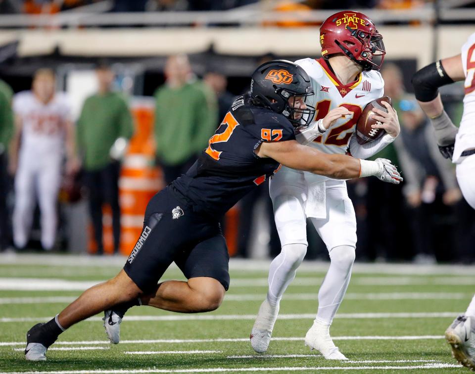 Nov 12, 2022; Stillwater, Oklahoma, USA;  Oklahoma State's Nathan Latu (92) sacks Iowa State's Hunter Dekkers (12) in the fourth quarter during the college football game between the Oklahoma State Cowboys (OSU) and the Iowa State Cyclones at Boone Pickens Stadium. OSU won 20-14. Mandatory Credit: Sarah Phipps-USA TODAY Sports