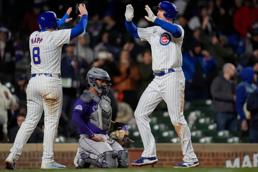 Chicago Cubs’ Garrett Cooper, right, hive-fives Ian Happ after Cooper after hitting a three-run home run during the sixth inning of a baseball game against the Colorado Rockies, Tuesday, April 2, 2024, in Chicago.