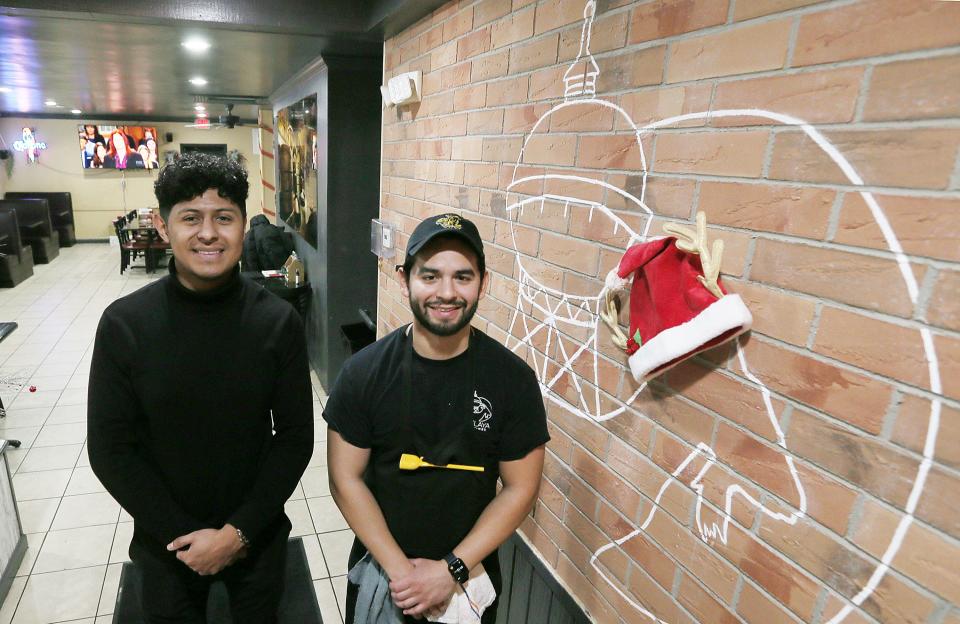 Owners of Celaya Tex-Mex, Jesus Frias and Kevin Fajardo (right), pose next to the logo at their restaurant on South Duff Avenue in December. Photo by Nirmalendu Majumdar/Ames Tribune