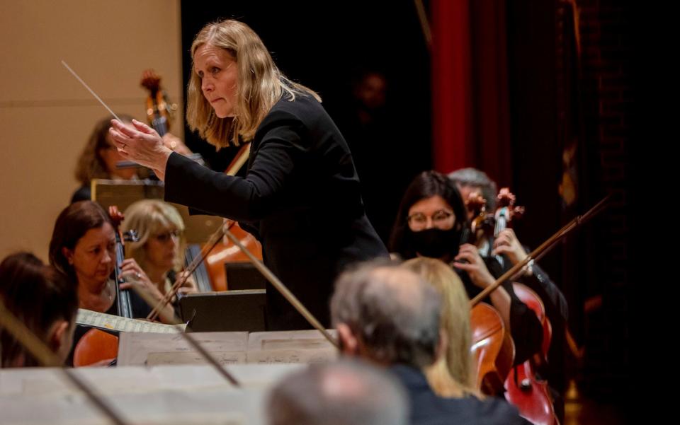 Music Director & Conductor of the Warren Symphony Orchestra, Gina Provenzano, leads the orchestra in front of middle school and elementary students inside the Warren Woods Community Auditorium at Warren Woods Middle School in Warren on Oct. 27, 2022. 