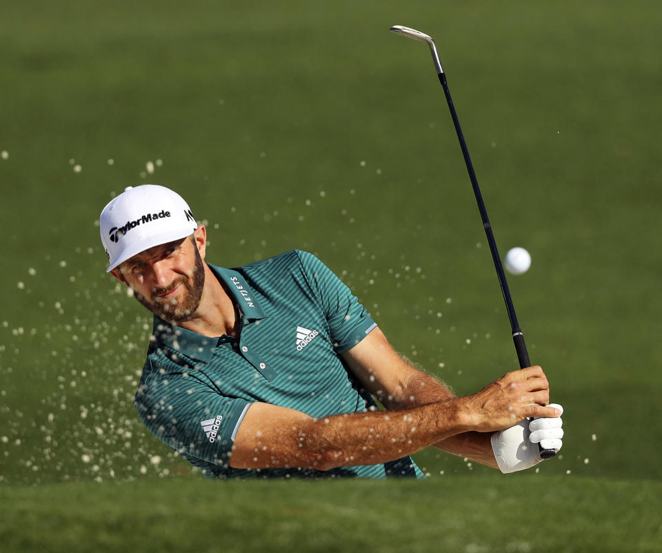 In this Tuesday, April 4, 2017, file photo, Dustin Johnson hits from a bunker to the second green during a practice round at the Masters golf tournament, in Augusta, Ga. The world's No. 1-ranked player was forced to withdraw from the Masters on Thursday because of a lower back injury suffered less than 24 hours earlier in a freak fall at the home he was renting for the week. (Curtis Compton/Atlanta Journal-Constitution via AP, File)