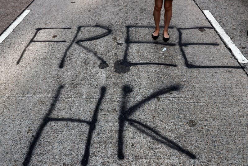 An anti-government demonstrator stands on a graffiti on a road during a protest in Central, Hong Kong