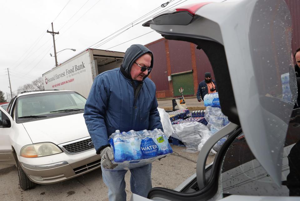 George Mager of Second Harvest Food Bank of the Mahoning Valley loads water into East Palestine, Ohio, residents' cars Friday.