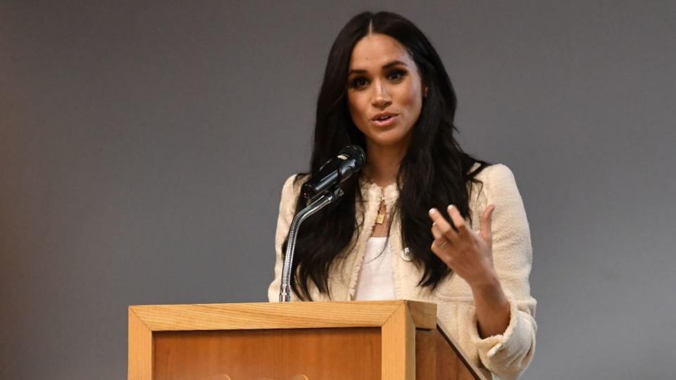 Meghan Markle speaks from behind a podium.