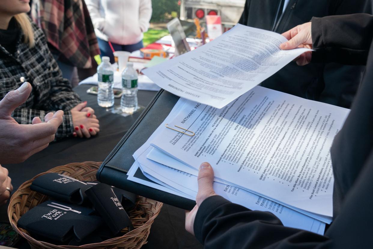 Nathaniel Pagendarm, 24 hands his resume to Peter Chekijan (L) of Twin Fork Beer Co. at the Employers Only Long Island Food, Beverage and Hospitality Job Fair on October 19, 2021 in Melville, New York.