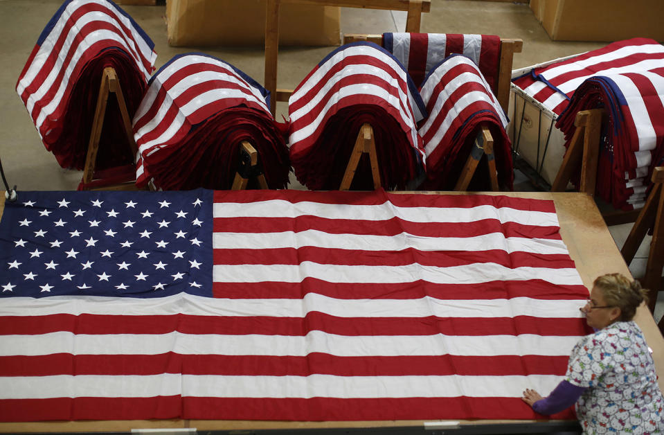 <p>A worker unfurls an American flag at the FlagSource facility in Batavia, Illinois, U.S., on Tuesday, June 27, 2017. (Photo: Jim Young/Bloomberg via Getty Images) </p>