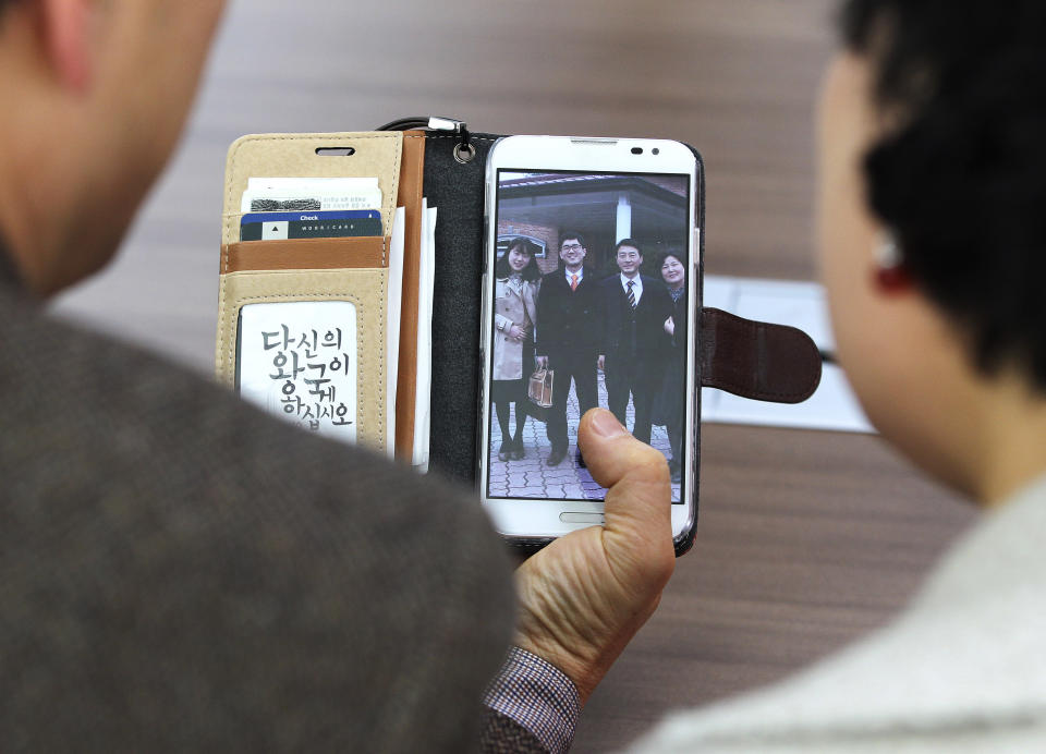 In this Friday, Jan. 9. 2014 photo, Jeon Jang-Beom, left, and Yoon Hyun-Jin show their family photo taken with their son Jeon Seong-Jin, second from left in the picture, during an interview in Seoul, South Korea. Jeon Seong-Jin, a 26-year-old dentist, is being punished for a crime that is not a crime at all in most of the world. A Jehovah’s Witness, he has refused to become a soldier in South Korea, where all able-bodied male citizens are required to serve about 21 months in the army. More than 660 conscientious objectors were jailed each year in South Korea from 2004 to 2012, far more than any other country. Eritrea comes in second with only about 50 imprisoned, according to the official website of Jehovah’s Witnesses, who often refuse military service because they believe the Bible forbids warfare. (AP Photo/Ahn Young-joon)